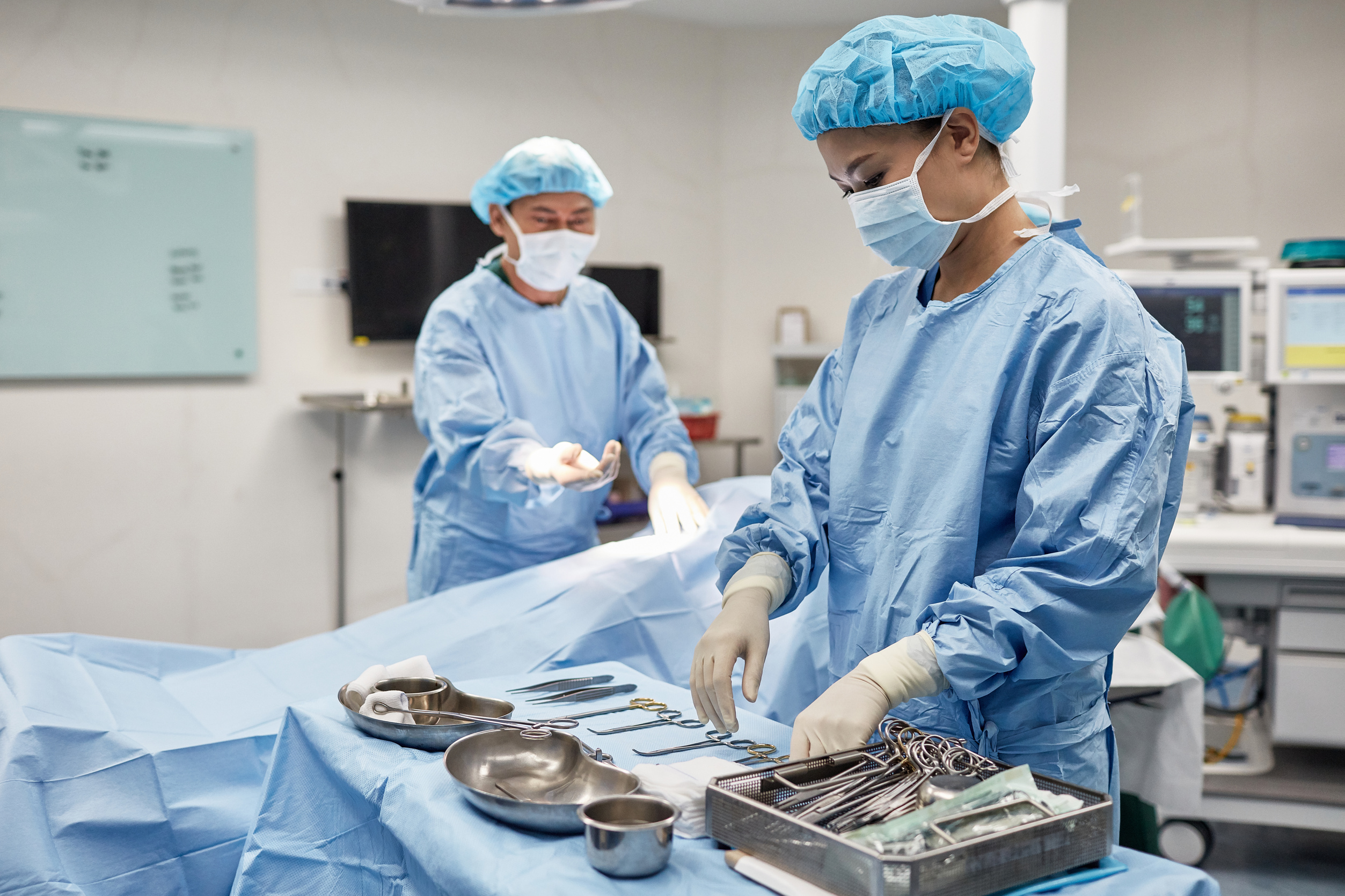 Surgical Tech Selecting Instrument to Hand to Surgeon